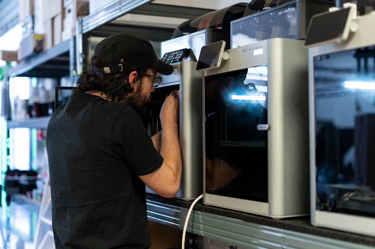 Photo d'une personne qui travaille sur une imprimante 3D